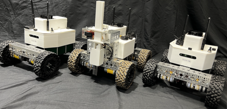 Three Hammerhead robot platforms in a workshop, with wheeled chassis and equipment housings